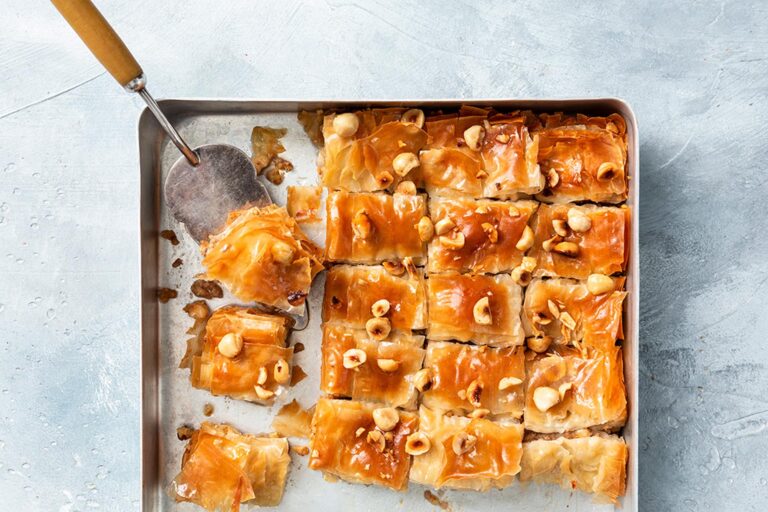 Gesneden baklava in een ovenschaal met taartschep