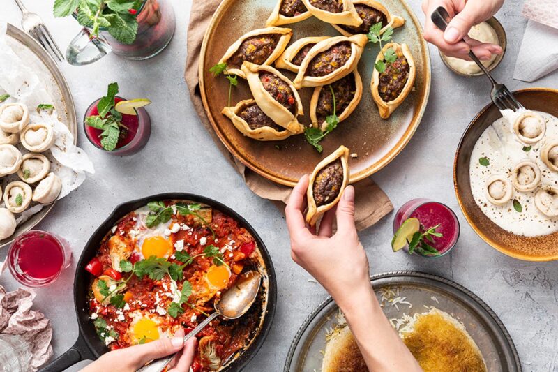 Mezze en drankjes op een tafel met handen die eten pakken foodstyling Nerissa Haak